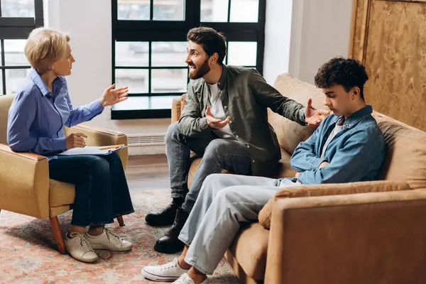 Ofiste doktor ya da sosyal hizmet görevlisiyle konuşan baba ve gencin portresi. Aile sorunları, gençlik sorunları, terapist, tavsiye, yardım kavramı