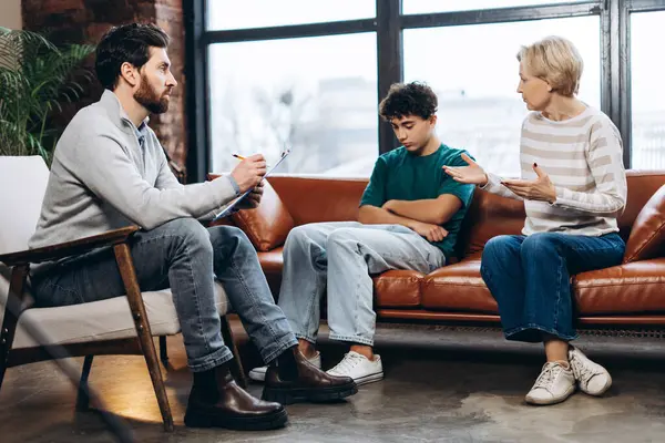 Erkek psikoloğa genç oğluyla ilgili sorunu açıklayan üzgün kadının portresi. Danışmanlık terapisi. Psikoloji tedavisi