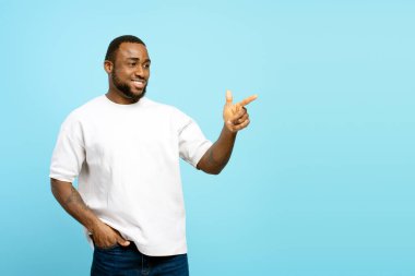 Afro-Amerikan bir adamın mavi arka planda izole edilmiş, reklam, promosyon ya da bilgi içeren ilginç bir şeyi işaret eden stüdyo portresi. Reklam kavramı