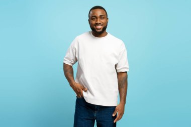Gülümseyen yakışıklı Afro-Amerikan adam mavi arka planda el ele poz veriyor. Reklam kavramı