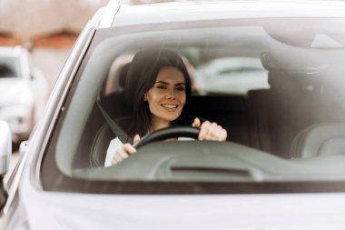 Mutlu bir Latin, parlak, modern bir araba kullanıyor. Önündeki yola odaklanmışken ışıl ışıl gülümsüyor. İşe gidiş yolculuğunun tadını çıkarıyor ve günlük seyahatinin heyecanını kucaklıyor. Ulaşım kavramı