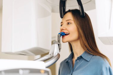 Dişçi kliniğine gelen radyografi cihazlarıyla 3D röntgen çeken kadın portresi. Diş tedavisi, radyoloji, panoramik tarayıcı