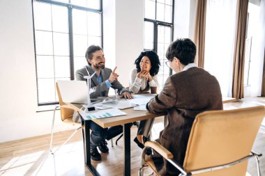 Mühendisler, parlak, modern ofis alanındaki bir toplantı sırasında yenilenebilir enerji projesiyle ilgili bir tartışmaya giriyorlar.