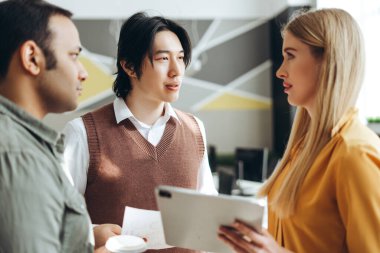 Pazarlama ekibi, modern ofisteki bir toplantıda pazar verilerini analiz ediyor ve proje stratejisini tartışıyor.