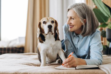 Mutlu, olgun bir kadın, sevgili av köpeğiyle yatakta uzanıp, rahat evinde rahat ve rahat anların tadını çıkarırken günlüğünü yazıyor. Hayvan konsepti