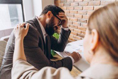 İş kadını, ofisteki proje başarısızlığıyla ilgili kötü haberlerden sonra üzgün erkek arkadaşını teselli ediyor.