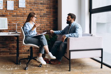 Modern bir ofiste terapi seansında hasta sorunlarını dinlerken not alan psikolog.