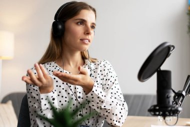 Genç bir kadın, kulaklık takıp mikrofona konuşurken ses kaydediyordu. Ev stüdyosunun rahatlığından podcast veya çevrimiçi radyo programı yapıyordu. Canlı, canlı konsept