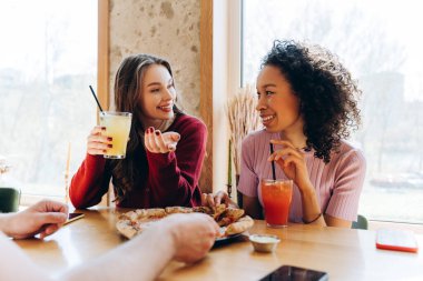 İki genç kadın sıcak bir restoranda pizza ve içki paylaşıyor, canlı sohbetler yapıyorlar ve birlikte keyifli bir öğle yemeğinin tadını çıkarıyorlar. Arkadaşlık, kavramı bozmak.