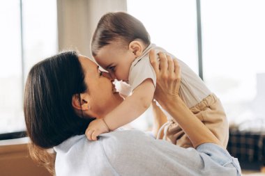 Yavrusuyla sessiz vakit geçirmekten hoşlanan genç bir annenin portresi, onu eve yakın tutuyor. Ebeveynlik, aile, aşk ve bakım kavramı