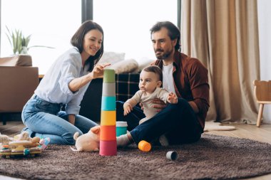 Mutlu aile, ebeveynler olarak birlikte vakit geçirir. Parlak ve davetkar bir odada oğluyla etkileşime geçip oynarlar. Ebeveynlik, aile, aşk ve bakım kavramı