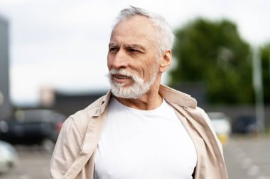 Şık, yaşlı bir adamın tasviri şehir ortamında güvenli bir şekilde yürüyor, şehir hayatından zevk alırken düşünceli bir şekilde uzaklaşıyor.