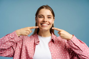 Neşeli genç bir kadının stüdyo portresi mükemmel gülüşünü gösteriyor beyaz dişler, diş sağlığı konsepti