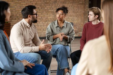 Grup terapi seansında tartışan hastalar ve terapistler, birbirlerine bağımlılık ve zihinsel sağlık sorunları konusunda yardım ediyorlar.