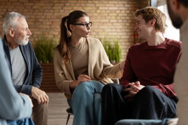 Grup terapisi sırasında bir çemberde oturan insanlar sorunları paylaşıyor ve destek alıyorlar