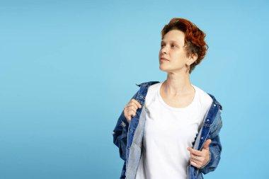 Kenar görünümlü genç bir mankenin portresi ve mavi arka planda poz vererek fotokopi alanına bakıyor. Bireysellik, çeşitlilik ve kendini ifade etme kavramı