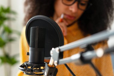 Yoğunlaştırıcı mikrofon odaklı, içerik oluşturucu arka planda ne söyleyeceğini düşünüyor, bir podcast bölümü kaydediyor