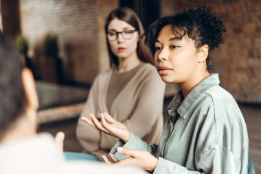 Afrika kökenli Amerikalı bir kadın grup terapisine aktif olarak katılıyor, deneyimlerini paylaşıyor ve diğer katılımcılar ve terapistlerle destekleyici bir ortam sağlıyor.