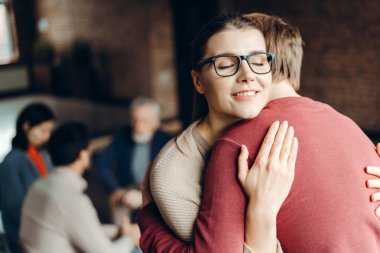 Mutlu genç kadın psikoterapi seansı sırasında adama sarılıyor. Destek konsepti