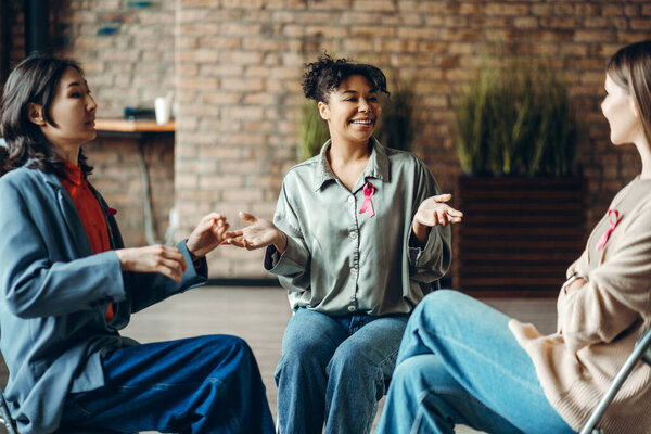 Group of multinational women supporting each other during breast cancer awareness month meeting. Health care concept