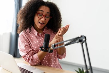 Güzel Afrikalı Amerikalı kadın şık gözlükler takıyor ve stüdyosundan bir podcast kaydediyor. Çevrimiçi, canlı, canlı konsept