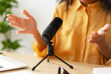 Radyo sunucusu mikrofona konuşuyor ve seçici bir şekilde el kol hareketi yapıyor. Profesyonel ekipman konsepti