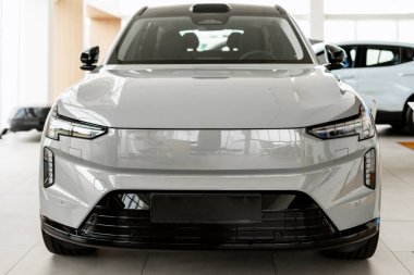 Gri elektrikli araba modern bir istasyonda lüks bir sergi salonunda, yenilikçi tasarım ve sürdürülebilir teknolojiyi ön plana çıkarıyor.