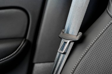 Lüks siyah deri bir araba koltuğuna bağlı emniyet kemerini kapatın. Araba kullanırken güvenliğin önemini vurgulayın.