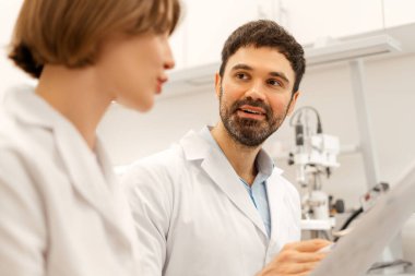 İki bilim adamı, bir erkek ve bir kadın, laboratuarda işbirliği yapıyorlar, verileri inceliyorlar ve araştırma bulguları hakkında bir tartışmaya giriyorlar. Tıbbi, iletişim konsepti