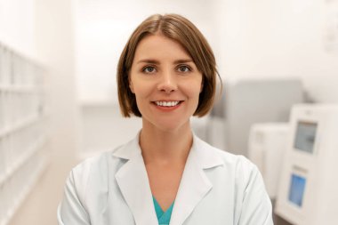 Modern bir tıp laboratuarında gülümseyen kendine güvenen, profesyonelliği ve uzmanlığı somutlaştıran, sağlık faaliyetlerine katılan ve gelişmiş tıbbi teknolojilerden yararlanan kendine güvenen bir kadın doktor.