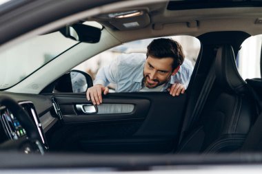 Hevesli müşteri eğildi, galerideki açık kapıdan yeni bir arabanın içine baktı, iç ayrıntıları büyük bir ilgiyle inceledi. Araba konsepti