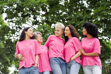 Çeşitli uluslar arası kadınlar göğüs kanseri farkındalığına destek veriyorlar ve gülümsüyorlar. Sağlık hizmeti kavramı