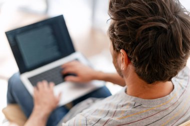 Odaklanmış adam, programcı içeride dizüstü bilgisayarla çalışıyor. Posta kontrolü. Kopya yazarı klavyeye yazı yazıyor. Çevrimiçi teknoloji kavramı