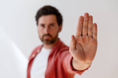Ciddi yakışıklı Latin adam, açık seçik odaklı, yakın çekim yaparak dur hareketi yapıyor. Uyarı kavramı