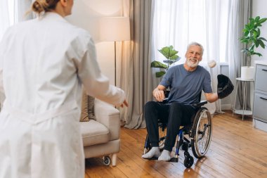 Tekerlekli sandalyedeki yaşlı adamla beyzbol oynayan bakıcı, olgun hastalara yardım eden mutlu hemşire. Destek konsepti