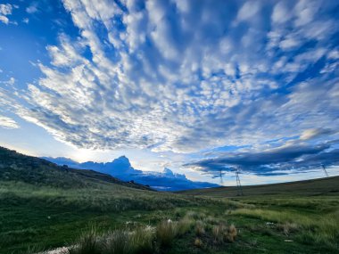 Gün batımında birçok çekici bulut ve doğal çimen çayırları.
