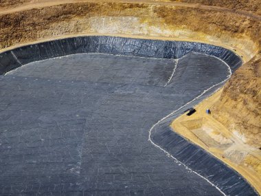 Madenin dibinde jeosentetik malzemelerle dolu bir yağmur suyu göleti inşaatı