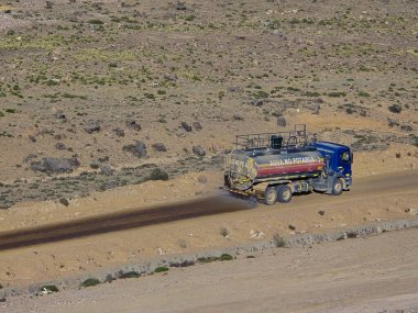 Yol kenarındaki su tankeriyle çevre denetimi ve toz kirliliği süreci.