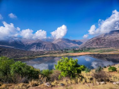Bulutları, otlakları ve lagünü olan yüksek And arazisi.
