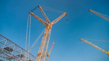 Stadyum inşaatı için metal yapıların kaldırılması sürecinde vinç kuleleri