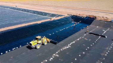 Su havuzu inşaatında kullanılan makinelerle jeomembran yerleştirme ve kurulum süreci