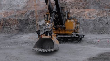 Ağır madencilik makineleri açık bir maden ocağında mineraller çıkarıyor.