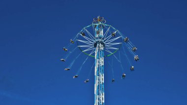 Bir atlıkarıncanın metal yapısını ve lunaparktaki diğer mekanik sürüşleri görüntüle