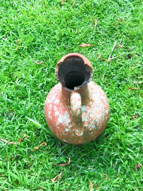 Yeşil çimen arka planda kırık sürahi