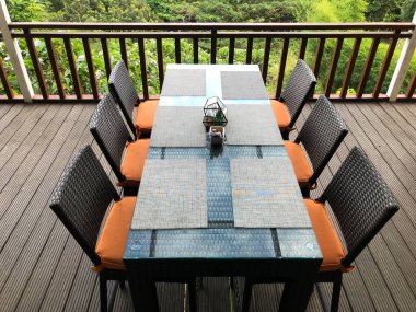 Koltuğu ve kahve masası olan büyük teraslı hoş bir dekor.