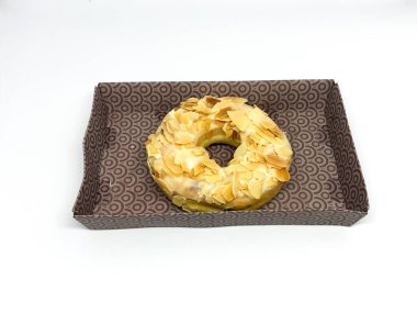 Beyaz arka planda izole edilmiş badem serpiştirilmiş çörek.