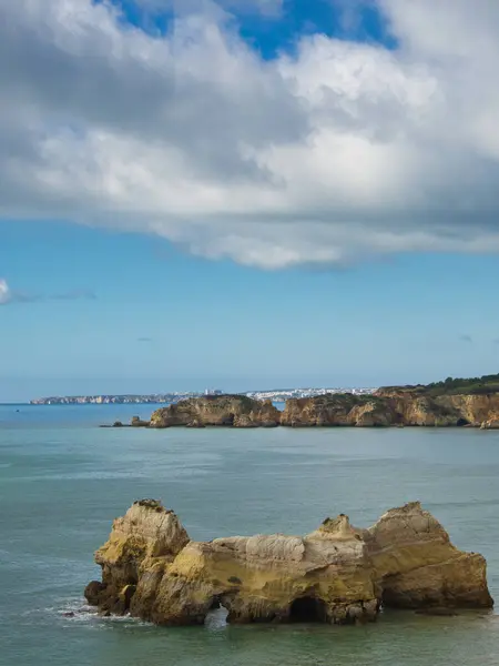 Portimo Peyzaj Sahil Hattı, Algarve, Portekiz, mavi gökyüzü gününde. Dalgalarla dolu engin okyanus, denizin ortasındaki kayalar ve uçurumlar..