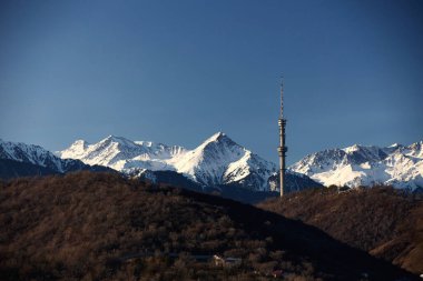 Almaty şehrindeki Kok-Tobe TV kulesi sabah sıradağlarının arka planına karşı. 