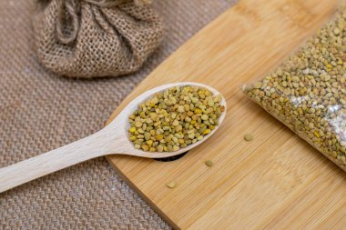 Propolis in a wooden spoon on a wooden bottom