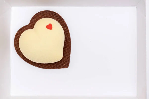 Vanilla cake on heart shaped chocolate chip cookie in white box, space for writing, heart message